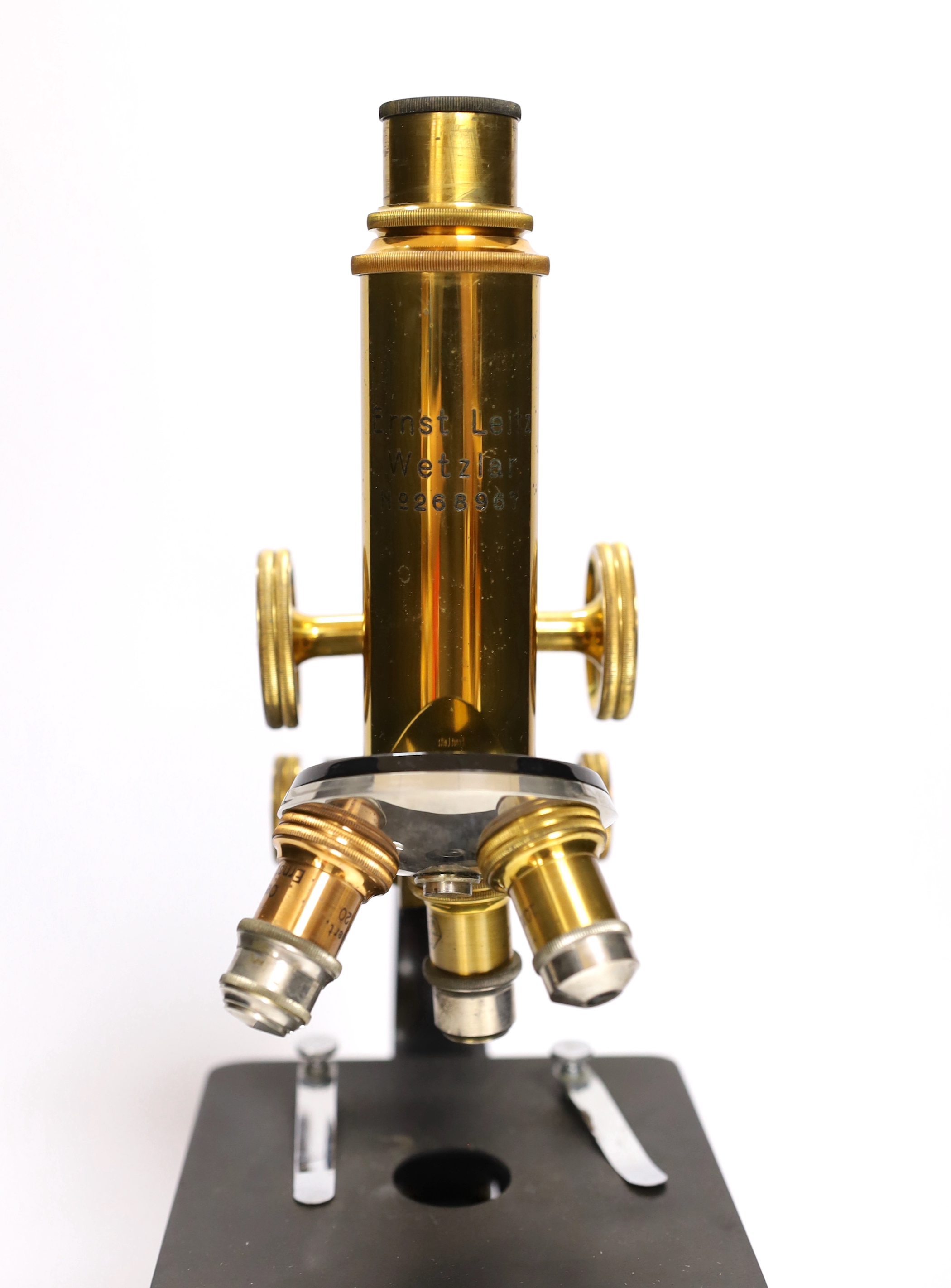 An early 20th century Leitz microscope in a teak case, with alternative lenses, card inserts and sliding compartment with glass slides, matching serial numbers stamped onto case and on magnification table
